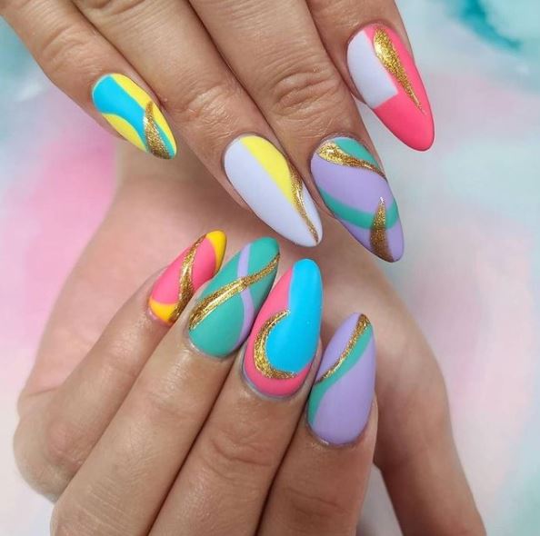 Geometric pastel nail design with swirls of gold
